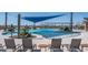 Relaxing pool area with shade sails and lounge chairs at 26404 W Zachary Dr, Buckeye, AZ 85396