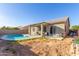 Home's back exterior, showcasing the pool and covered patio at 13585 W Ironwood St, Surprise, AZ 85374