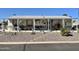Single-wide manufactured home with covered porch and well-maintained landscaping at 2400 E Baseline Ave # 301, Apache Junction, AZ 85119