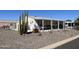 Single-wide manufactured home with covered porch, cacti, and rock landscaping at 2400 E Baseline Ave # 301, Apache Junction, AZ 85119