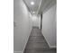Long hallway with gray laminate flooring and neutral walls at 9017 E Butternut Ave, Mesa, AZ 85208