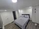 Bright bedroom with a gray bed, built-in closets and gray flooring at 9017 E Butternut Ave, Mesa, AZ 85208