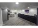 Open living room and kitchen with gray sectional sofa and wall-mounted TV at 9017 E Butternut Ave, Mesa, AZ 85208