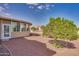 Backyard view showcasing a sunroom, gravel pathway, and lush greenery at 15906 W Sentinel Dr, Sun City West, AZ 85375