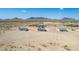 Aerial view of three new homes with desert landscape and mountain backdrop at 1587 S 391St Ave, Tonopah, AZ 85354