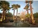 Night view of backyard with pond, waterfall, and palm trees at 14679 N Love Ct, Fountain Hills, AZ 85268