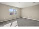 Spacious bedroom with neutral carpeting and large window at 1471 S 239Th Dr, Buckeye, AZ 85326