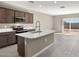Modern kitchen with island, stainless steel appliances, and tile flooring at 1471 S 239Th Dr, Buckeye, AZ 85326