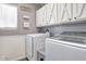 Bright laundry room with white cabinets and modern appliances at 775 E Leslie Ave, San Tan Valley, AZ 85140