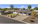 Single story home with solar panels and a well-maintained front yard at 7428 E Carol Cir, Mesa, AZ 85208