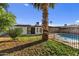 Backyard with a pool, palm tree, and grass at 7428 E Carol Cir, Mesa, AZ 85208