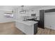 Modern kitchen with white and dark cabinetry, breakfast bar, and stainless steel appliances at 7428 E Carol Cir, Mesa, AZ 85208