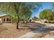 Landscaped backyard with gravel and mature trees at 15758 W Edgemont Ave, Goodyear, AZ 85395