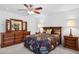 Bedroom with wooden dresser and ceiling fan at 15758 W Edgemont Ave, Goodyear, AZ 85395