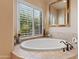 Luxurious bathroom with soaking tub, large mirror, and natural light at 2554 N Tambor --, Mesa, AZ 85207