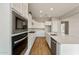 Modern kitchen with white cabinets, stainless steel appliances, and an island at 22508 E Orchard Ln, Queen Creek, AZ 85142