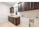 Bright laundry room with dark wood cabinets and granite countertops at 25952 S 224Th Pl, Queen Creek, AZ 85142