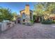 Outdoor kitchen and patio area with a stone fireplace and seating at 8000 E Mariposa Grande Dr, Scottsdale, AZ 85255