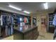 Large walk-in closet with custom shelving and island at 8000 E Mariposa Grande Dr, Scottsdale, AZ 85255