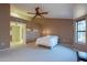 Bright bedroom with ceiling fan and large window at 13047 W Peach Blossom Dr, Sun City West, AZ 85375
