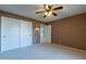 Bright bedroom featuring double door closet and ceiling fan at 13047 W Peach Blossom Dr, Sun City West, AZ 85375
