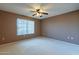 Spacious bedroom with ceiling fan and carpeted floors at 13047 W Peach Blossom Dr, Sun City West, AZ 85375