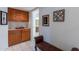 A hallway with wood cabinets, a bench, and framed artwork at 13047 W Peach Blossom Dr, Sun City West, AZ 85375