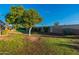 Landscaped backyard with mature trees and a brick wall at 13047 W Peach Blossom Dr, Sun City West, AZ 85375