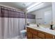 Bathroom with vanity, shower/tub combo and striped curtain at 13047 W Peach Blossom Dr, Sun City West, AZ 85375