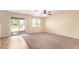 Large living room with neutral carpet and sliding door access to the backyard at 18774 N Ibis Way, Maricopa, AZ 85138