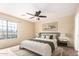 Bright bedroom with large window, ceiling fan, and plush bedding at 18774 N Ibis Way, Maricopa, AZ 85138