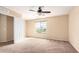 Well-lit bedroom featuring a large window and ceiling fan at 18774 N Ibis Way, Maricopa, AZ 85138