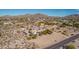 Aerial view of single-story home nestled in a desert setting with mountain backdrop at 8052 E Mcdowell Rd, Mesa, AZ 85207