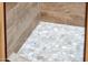 Modern shower with pebble floor and tile surround at 23228 N Gaviota Dr, Sun City West, AZ 85375