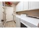 Bright laundry room with white cabinets and a Whirlpool washer and dryer at 23228 N Gaviota Dr, Sun City West, AZ 85375