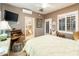 Bright bedroom with a queen-size bed, en-suite bathroom, and French doors at 23228 N Gaviota Dr, Sun City West, AZ 85375