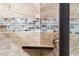 Modern shower with beige and blue glass tile and corner shelf at 23228 N Gaviota Dr, Sun City West, AZ 85375