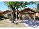 Tan stucco house with tile roof, a two-car garage, and mature landscaping at 15626 N 50Th St, Scottsdale, AZ 85254
