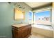 Bathroom with soaking tub, vanity with granite top and large window at 29408 N 244Th Dr, Wittmann, AZ 85361