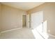 Spacious bedroom with double doors leading to the bathroom, carpeted floors and neutral walls at 29408 N 244Th Dr, Wittmann, AZ 85361