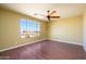 Bedroom with hardwood floors, ceiling fan, and a large window offering views at 29408 N 244Th Dr, Wittmann, AZ 85361