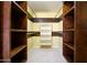 Large walk-in closet with wood shelving and hanging rods at 29408 N 244Th Dr, Wittmann, AZ 85361
