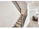 Modern staircase with dark metal railing and carpeted steps at 5819 N 191St Dr, Litchfield Park, AZ 85340