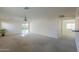 Spacious living room with carpet, sliding doors and ceiling fan at 44977 W Miraflores St, Maricopa, AZ 85139