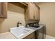 Functional laundry room with white sink, cabinetry, and modern appliances at 37440 N 104Th Pl, Scottsdale, AZ 85262