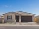 Tan house with brown garage door and landscaped front yard at 4681 N 177Th Ln, Goodyear, AZ 85395