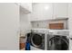 Functional laundry room with washer, dryer, and storage at 10116 W Audrey Dr, Sun City, AZ 85351