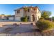 Two-story house with tan stucco exterior, two-car garage, and desert landscaping at 8143 E Obispo Ave, Mesa, AZ 85212