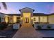 Stunning modern home exterior with a covered entryway and nicely landscaped front yard at 31006 N Memory Ln, Queen Creek, AZ 85142