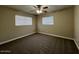 Spacious bedroom with two windows, ceiling fan, and carpet flooring at 3542 E Earll Dr, Phoenix, AZ 85018